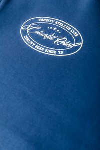 Felpa blu con una texture liscia, caratterizzata da un logo stampato bianco che riporta le scritte "Varsity Athletic Club" e "Colorful Rebel" in un design ovale.