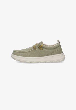 Sneaker casual slip-on verde chiaro con suola bianca imbottita, dettaglio con lacci e anello in tessuto sul tallone su sfondo bianco.