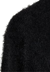 Gros plan sur un tissu noir pelucheux avec des fibres douces et texturées créant une surface dense et duveteuse.