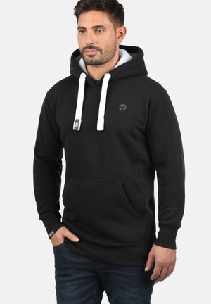 Sort hoodie med en frontlomme, hvide snore og et lille logo på brystet. Lavet af blødt stof med ribbede manchetter og kant.