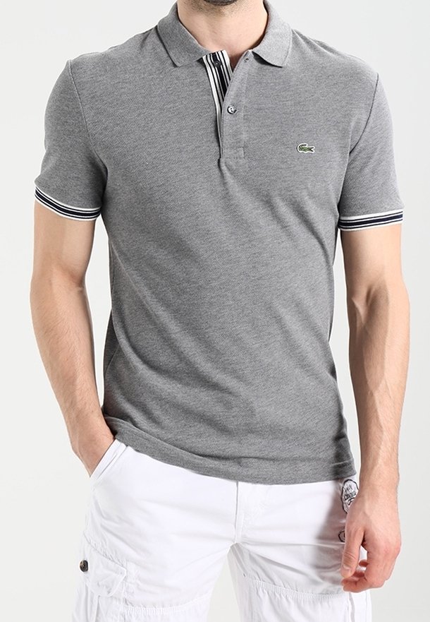 Polo gris avec col, manches courtes et accents rayés aux poignets. Présente un logo vert sur la poitrine. Fabriqué en coton.