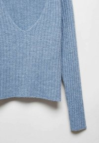 Pull côtelé bleu à manches longues avec un col en V profond. Confectionné dans un matériau doux, il présente une coupe décontractée et une finition texturée.