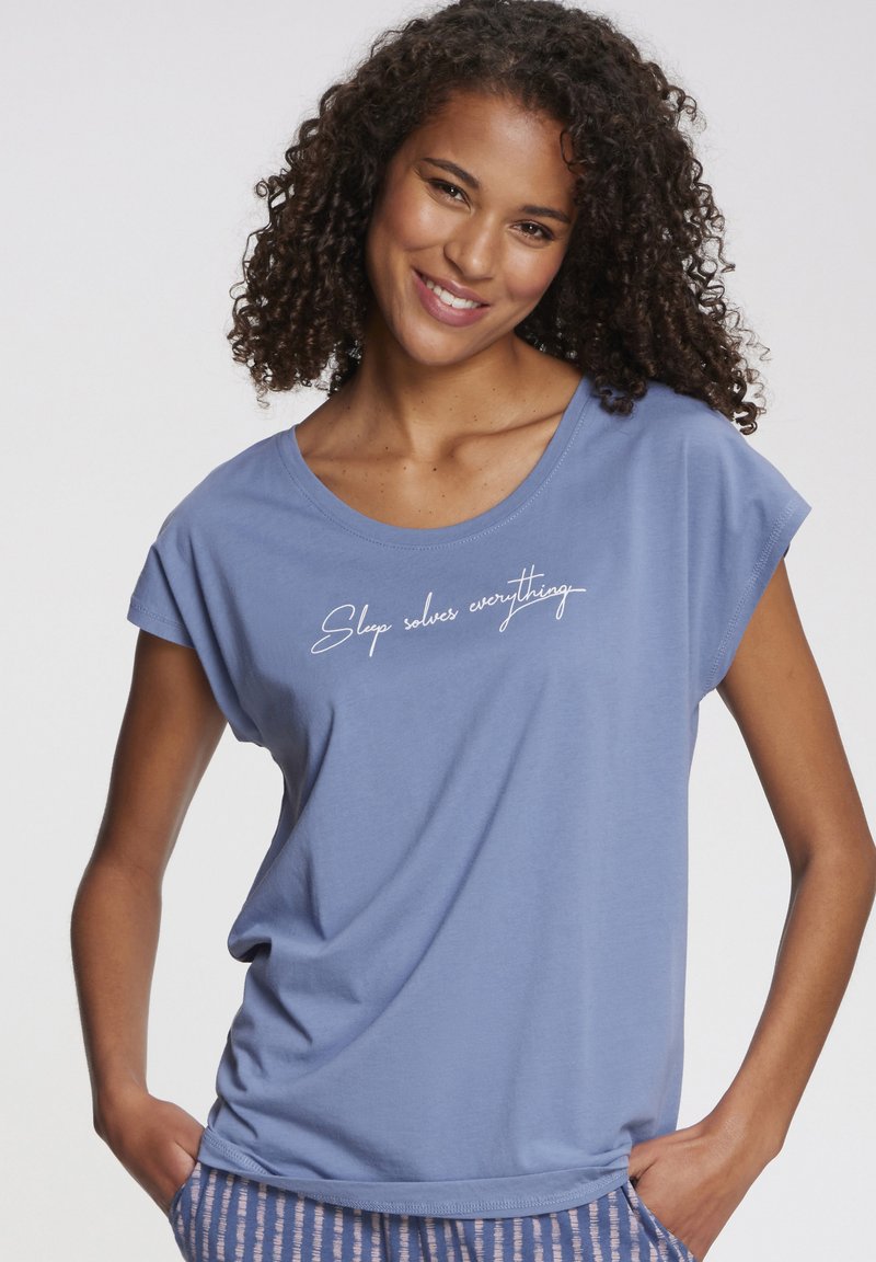 Light blue short-sleeve t-shirt made from soft fabric, featuring a white cursive text design that reads "Sleep solves everything."