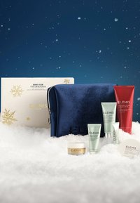 Gavesett med marineblå fløyelspose, gullfargede detaljer, juletema-eske, fem hudpleieprodukter i ulike størrelser, inkludert en rød dusjkrem.