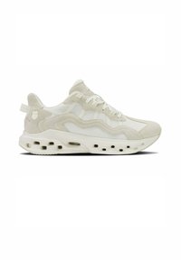 Vista laterale di una sneaker in rete bianco e beige chiaro con chiusura con lacci e suola perforata per ventilazione.