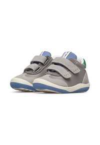 Graue Kinderschuhe verfügen über zwei Klettverschlussriemen, eine Textur aus Leder und Wildleder, eine weiße Zwischensohle und eine blaue Gummisohle.