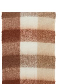 Rutet uldtæppe med store felter i nuancer af brun, beige og creme. Blød tekstur med en gradienteffekt hen over firkanterne.
