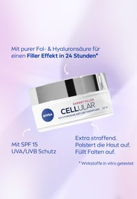NIVEA CELLULAR Expert Filler cream in a round white jar with a silver lid. Text highlights ingredients and SPF 15 protection on a soft gradient background.