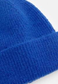 Berretto a maglia blu con una finitura morbida e texturizzata. Presenta un motivo a coste e un orlo piegato in fondo.