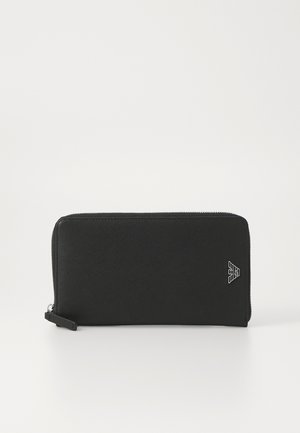 Zwarte ritstas gemaakt van textuurmateriaal, met zilveren hardware en een logo-accent op een hoek. Rechthoekige vorm.