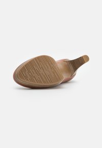 Semelle de chaussure en cuir marron clair avec un motif de grip texturé. Le talon présente une transition lisse vers l'arrière légèrement surélevé.