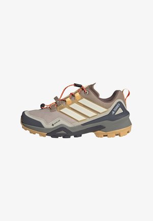 Leichte Outdoorschuhe in Beige und Grau, mit einer robusten Sohle, Obermaterial aus Mesh, GORE-TEX-Branding und orangefarbenen Schnürsenkeln mit einstellbaren Schlaufen.