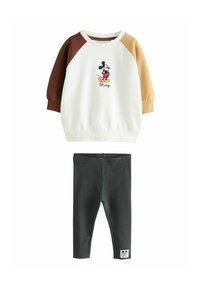 Setti, joka sisältää kermaisen yläosan ruskeilla ja vaaleanruskeilla raglan-hiisilla, jossa on koristeltu Mickey Mouse -grafiikka, ja tummanvihreät leggingsit.