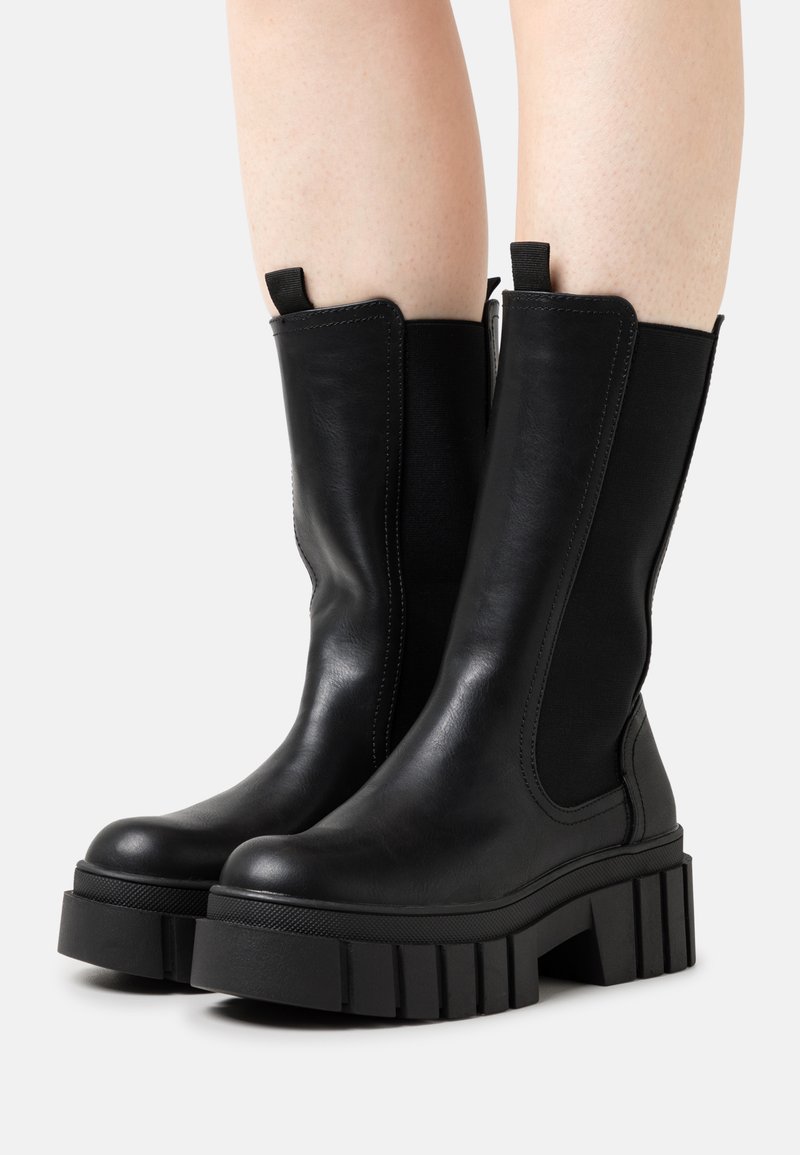 Black ankle boots with a chunky rubber sole, elastic side panels, and a smooth leather upper. Lightweight design with pull tabs for easy wear.