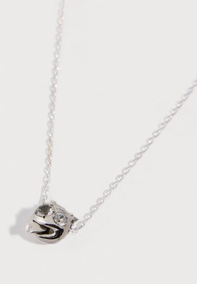 Silberne Halskette mit einer kleinen Hundegesichtsanhänger, der zwei Kristallaugen und eine herausgestreckte Zunge zeigt.