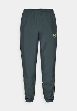 Ciemnozielone spodnie sportowe z elastycznym paskiem, żółtymi paskami po bokach i małym logo w górnym lewym rogu. Wykonane z lekkiego materiału.