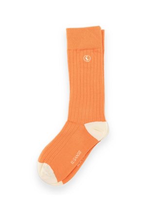 Par de calcetines naranja acanalados con talones y dedos blancos, con un pequeño logo circular blanco cerca del puño y texto blanco en el pie.