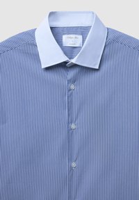 Camicia aderente a righe blu e bianche con colletto bianco, dotata di chiusure a bottoni e tessuto strutturato. L'etichetta riporta "Calliope Man, L."