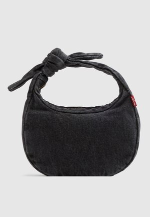 Malá černá ramenní taška z denimu s uzlovaným popruhem a zapínáním na zip, s červenou látkovou visačkou Levi's na boku.