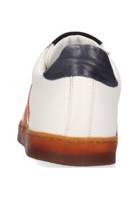 Zapatilla de cuero con un cuerpo predominantemente blanco, acentos naranjas, un talón azul marino y una suela de goma con un degradado de marrón a transparente.