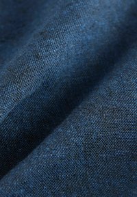 Texturerad tyg i mörkblå nyanser som visar ett vävt mönster med subtila variationer, vilket skapar ett mjukt och hållbart utseende.