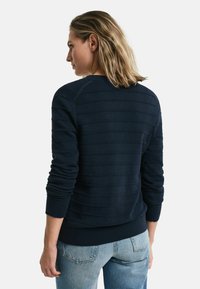 Marineblauer Pullover mit geripptem Stoff, langen Ärmeln und rundem Ausschnitt. Mit horizontalen Streifen und einem enganliegenden Saum.