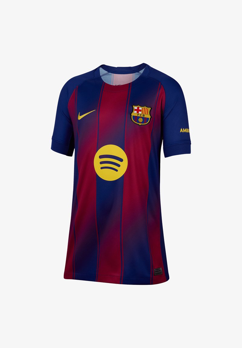 Camiseta del FC Barcelona en rayas rojas y azules, hecha de tejido transpirable. Presenta el logo de Nike, un círculo del patrocinador Spotify y el escudo del club.