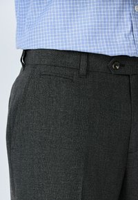 Gray textured trousers with a straight-leg design and a flat front. Includes a button closure and pocket detail, paired with a blue checkered shirt.