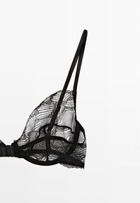 Black lace bra with a triangular shape, featuring thin straps, floral patterns, and a sheer texture. Adjustable hooks and detailing at the edges.
