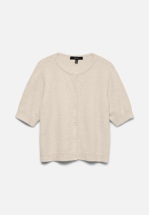 Svetlo bež kratek pulover na gumbke z okrolim izrezom, rebrastimi manšetami in robom, položen na ravno belo podlago.