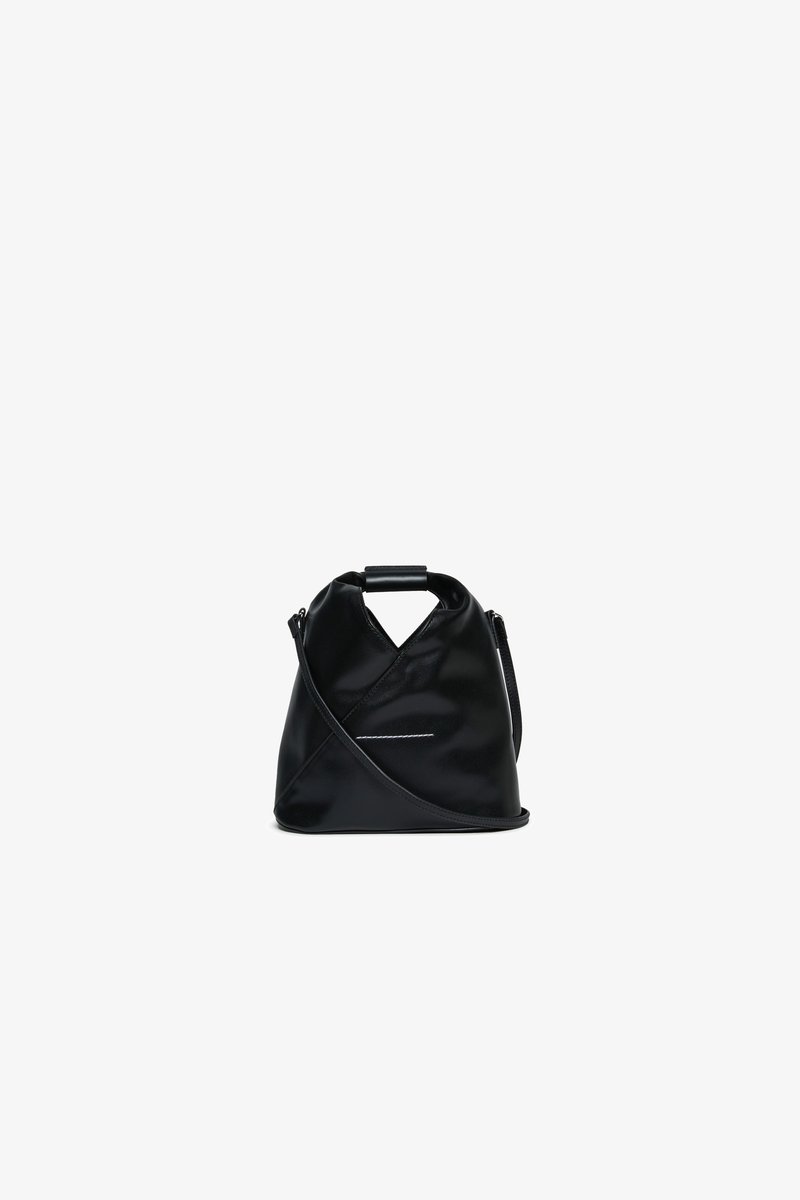 Μαύρη δερμάτινη τσάντα χειρός με μοναδικό σχέδιο σε σχήμα Χ, διαθέτει κοντό χερούλι και μακρύ ρυθμιζόμενο λουρί, καθώς και μια διακριτική ασημένια λεπτομέρεια.