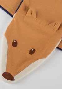 Coperta per bebé morbida marrone chiaro e crema con design di faccia di volpe, occhi ricamati, naso e piccole orecchie in tessuto su uno sfondo bianco.