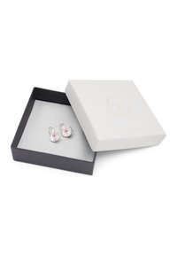 Pendientes de plata con diseños de piedras preciosas redondas y coloridas, presentados en una caja negra abierta con una tapa blanca texturizada.