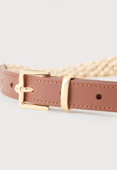 Καφέ δερμάτινη ζώνη με χρυσή αγκράφα και θηλιά, τοποθετημένη σε ουδέτερο φόντο, που αναδεικνύει τις λεπτομέρειες της ραφής και της αγκράφας.