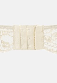 Grembiule in pizzo beige con fascia in satin, dotato di chiusure a gancio e occhiello e bordi in pizzo a scallop. Texture liscia con un intricato motivo floreale.