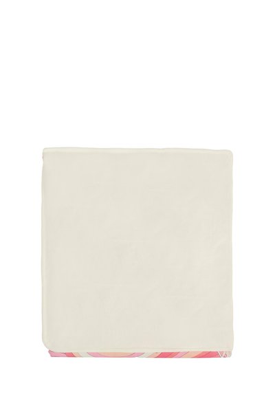 Koc polarowy z jednolitą, kremową górną warstwą i wzorzystym, różowym spodem z okrągłymi wzorami. Krawędzie wykończone są przeszyciem.