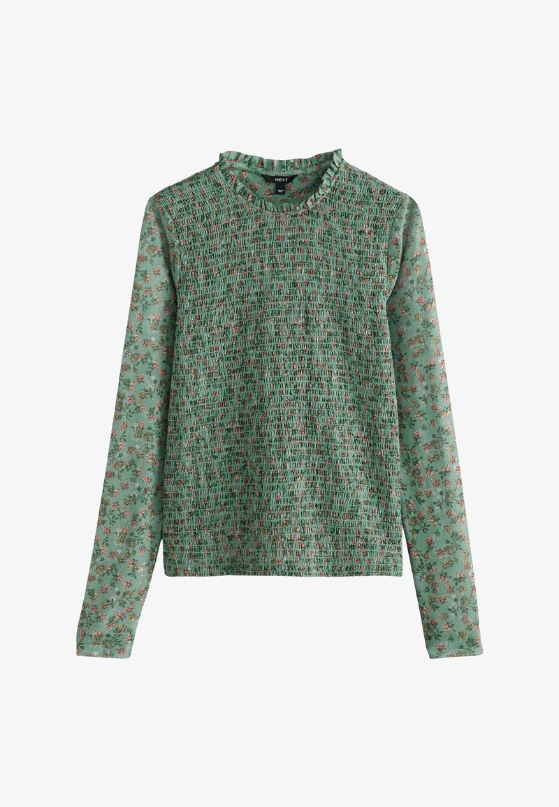 Green long-sleeve top with a smocked texture and floral print. Features a ruffled neckline and smooth fabric on sleeves.