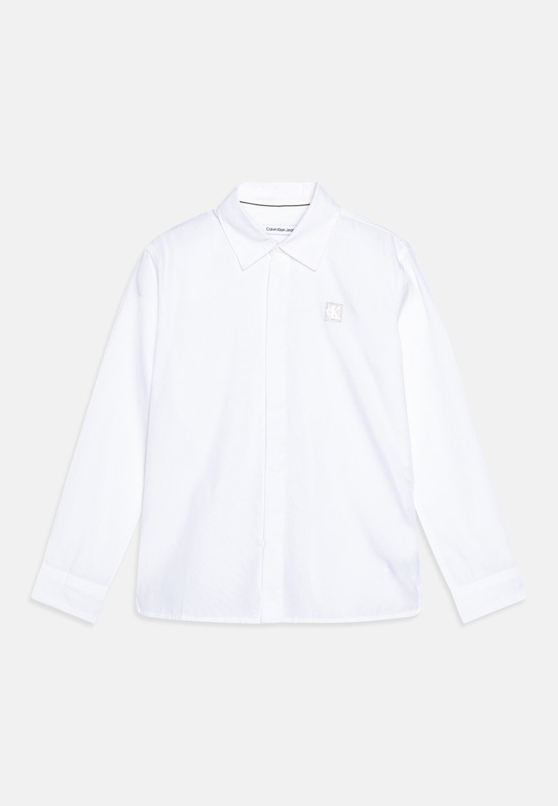Camicia bianca a maniche lunghe in cotone con colletto classico, dotata di una piccola etichetta con il logo Calvin Klein sul petto.
