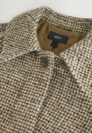 Hnědý a krémový kabát s vzorem houndstooth, s límečkem, obsahující jedno knoflík a hladkou hnědou podšívku. Viditelná značka.