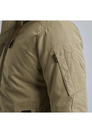 Tan geïsoleerde jas met een rits aan de voorkant, een capuchon met trekkoord en een patchzak op de mouw met een logosticker.