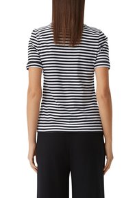 Black and white striped short-sleeve t-shirt with a rounded neckline, soft texture, and a straight hem, worn with black pants.