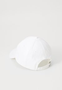 White baseball cap made of cotton, featuring a curved brim, six-panel design, ventilation holes, and adjustable strap at the back.