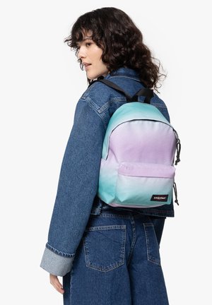 Pastel gradient backpack in light purple and teal. Made of fabric with a front pocket and adjustable straps. Logo patch on the front.