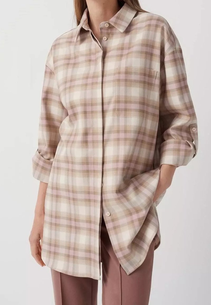 Överdimensionerad rutig skjorta i mjuk bomullsblandning, med beige, ljusrosa och vita färger. Knappstängning fram med uppvikta ärmar.