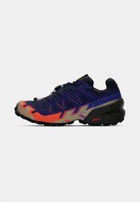 Sapatos de trail running nas cores azul marinho, roxo e laranja. Parte superior texturizada com detalhes refletivos, sola em borracha e sistema de amarração integrado para um ajuste seguro.