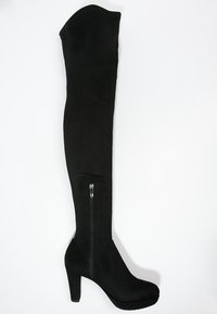 Bota de tacón alta de ante negro, con cremallera lateral y punta redondeada, exhibida sobre un fondo blanco.