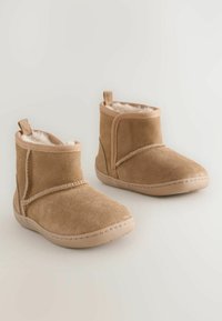 Hellbraune Wildleder-Ankle Boots mit Kunstfellfutter, elastischen seitlichen Einsätzen und gestickten Details auf einer konturierten Gummisohle. Kompaktes Design.