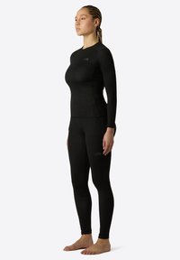 Schwarz langärmliges Sportoberteil und Leggings aus dehnbarem Material, mit nahtlosem Design und dezentem Logo-Detail.