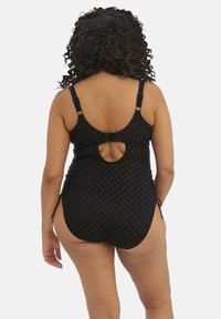 Bañador negro con un patrón texturizado, tirantes ajustables y un corte circular en la parte posterior. Los lazos laterales añaden detalles al diseño.