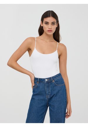 Body bianco a spalla stretta con scollo tondo, abbinato a jeans in denim blu a vita alta con tasche frontali e chiusura con bottone.
